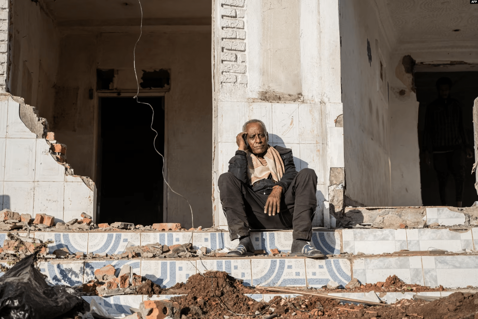 A man sits among the rubbles of a house during a planned demolition in the historical Piazza neighbouhood of Addis Ababa on March 17, 2024. Source: VOA Africa. 